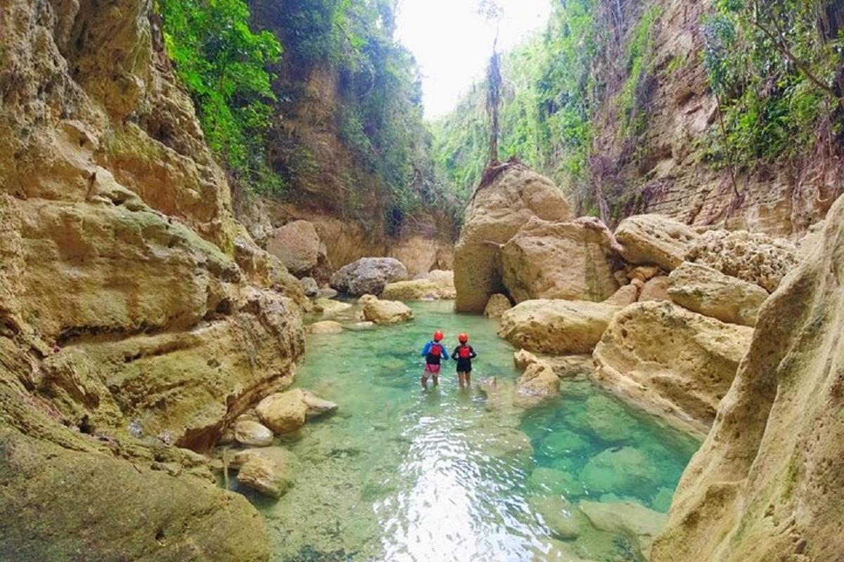 dua orang berdiri di sungai di ngarai