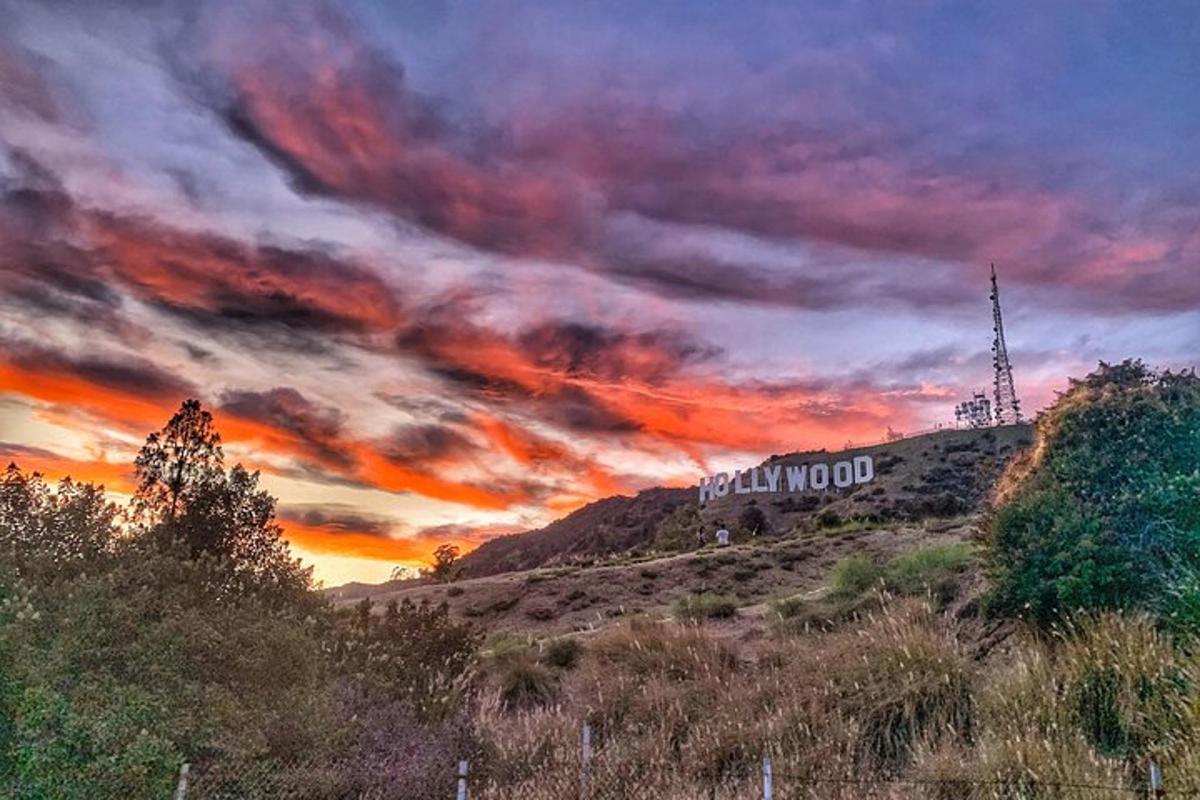 un edificio in cima a una collina con un tramonto