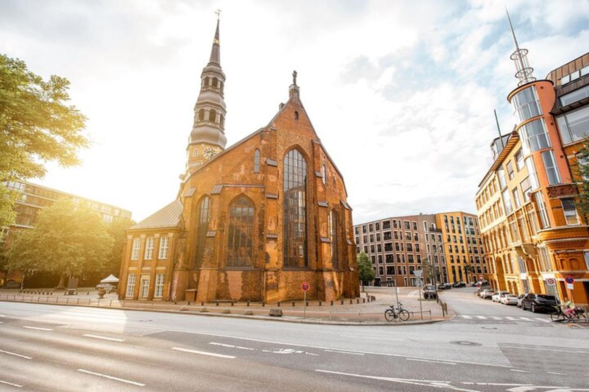 uma igreja antiga com uma torre alta em uma rua da cidade