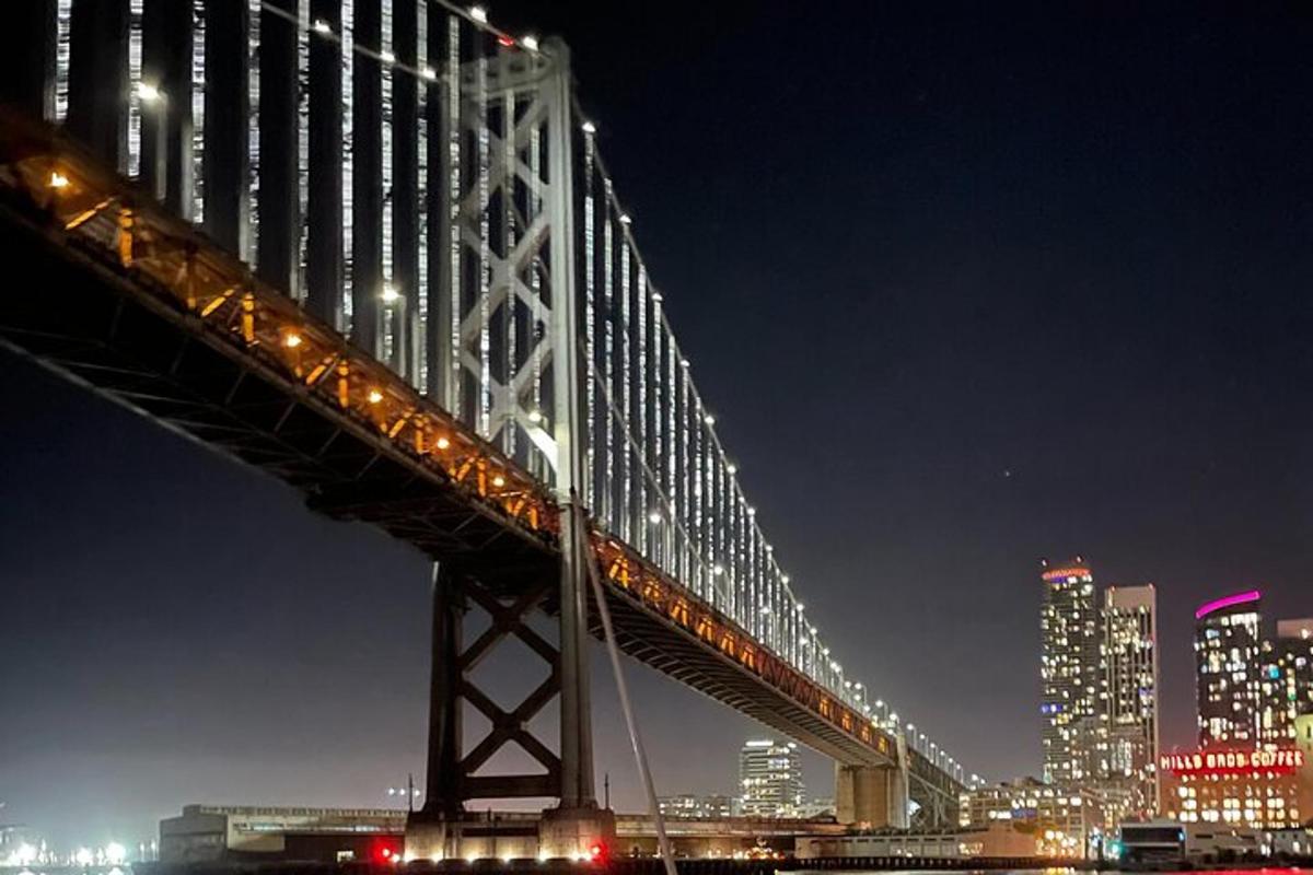 un ponte sopra un fiume con una città di notte