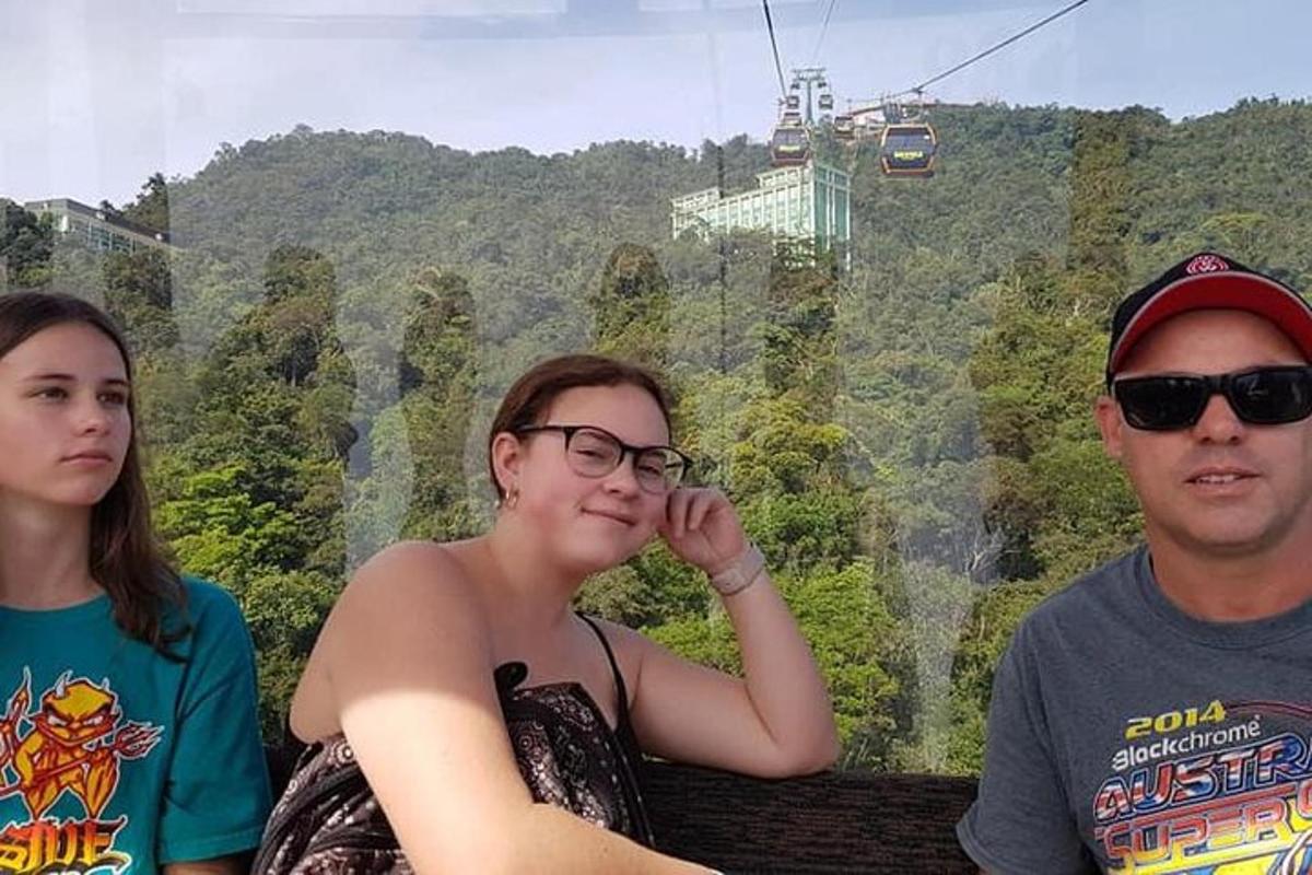 three people sitting on a gondola at the top of the mountain