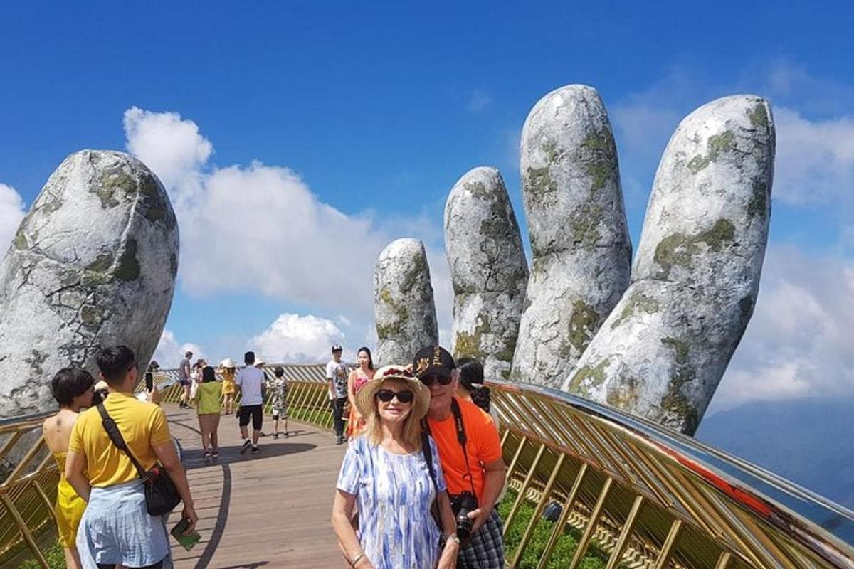 một người phụ nữ đứng trước một bức tượng có bàn tay khổng lồ