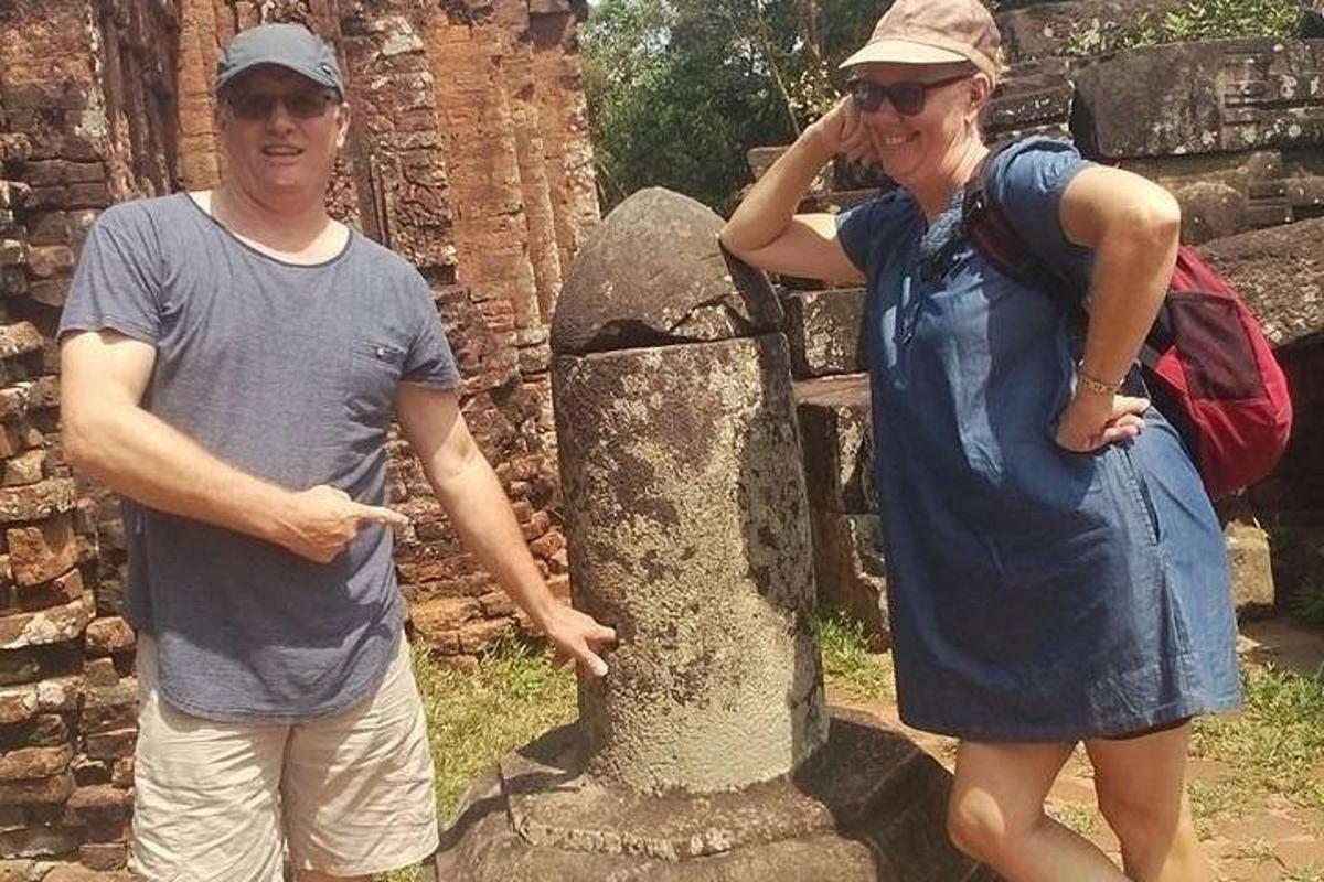 un uomo e una donna in piedi accanto a una statua