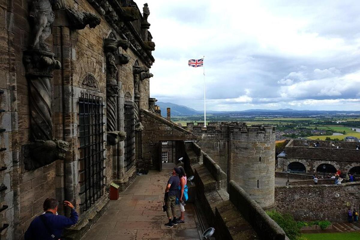 Un grupo de personas de pie en la ladera de un castillo.