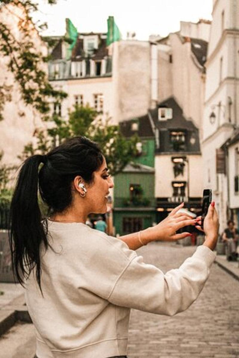 egy nő fényképez a mobiltelefonjával