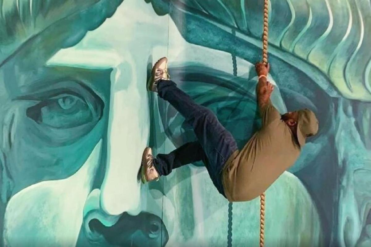 a person on a rope swing in front of a mural
