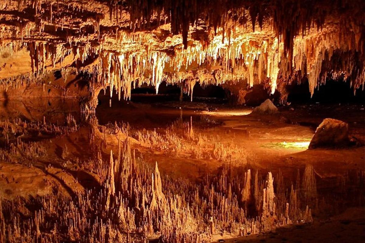 a cave with icicles hanging over a body of water