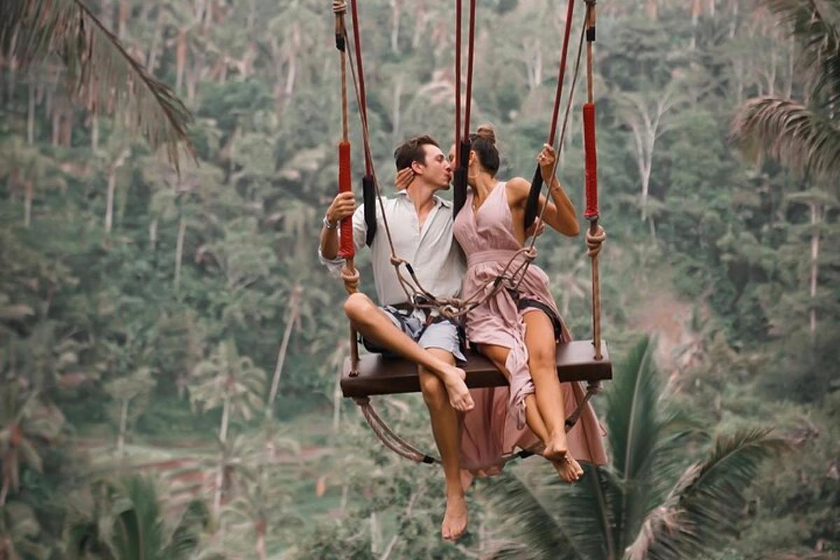 um homem e uma mulher sentados em um balanço na selva