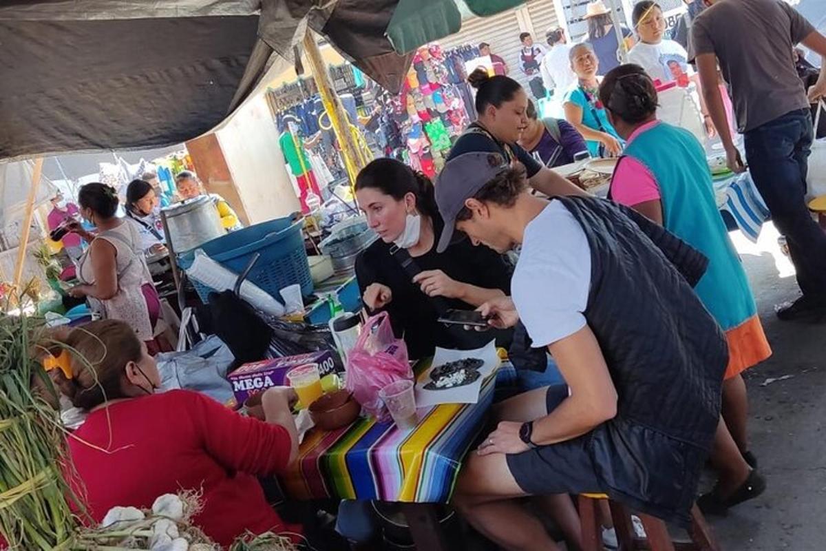 a group of people standing around a table in a market