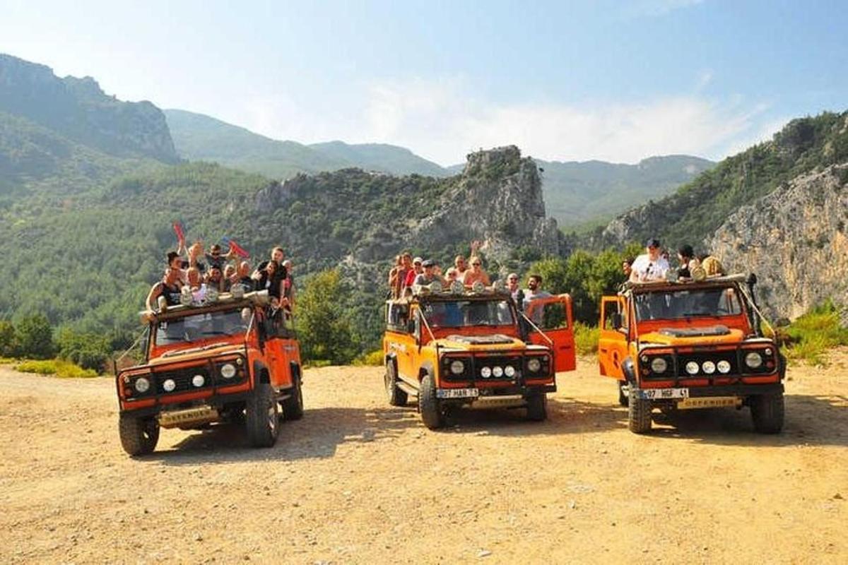 a group of people riding on the back of three dump trucks