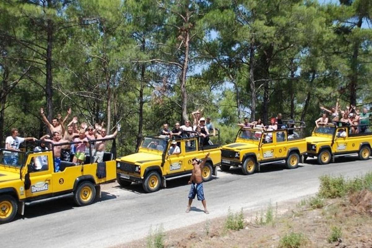 a group of people riding on the back of yellow jeeps