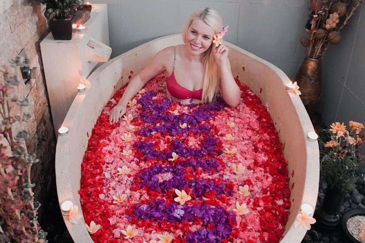 a woman sitting in a bath tub covered in flowers