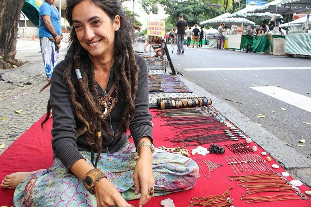 una donna seduta su una coperta rossa per strada