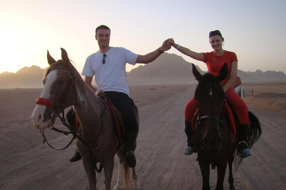 un uomo e una donna a cavallo nel deserto