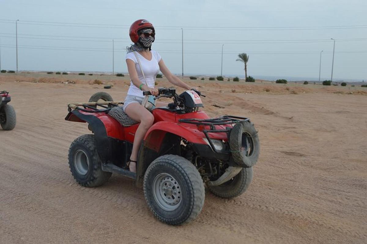 una donna in sella a un quad nel deserto