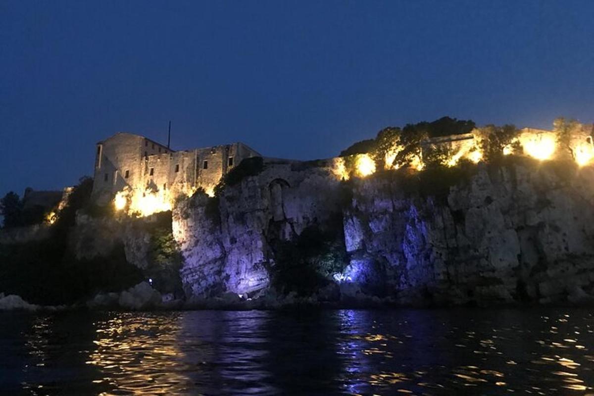 hrad stojící v noci na vrcholu útesu