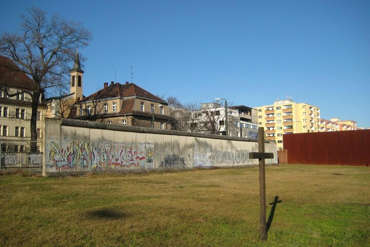 un muro con graffiti in un campo con edifici