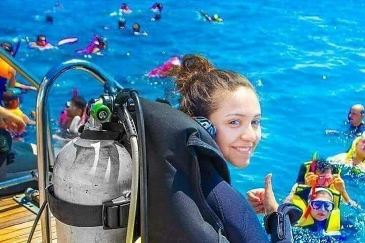 una ragazza in piedi in una piscina con una macchina fotografica