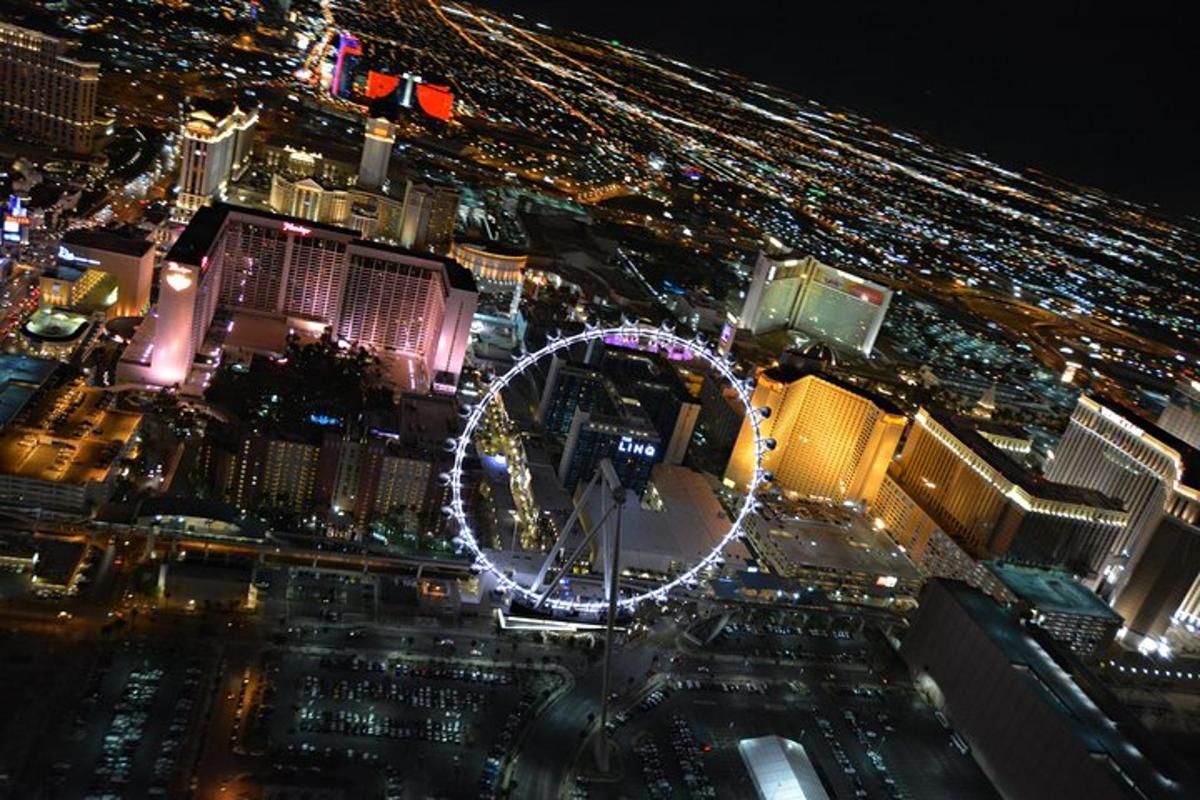 a lit up ferris wheel in a city at night