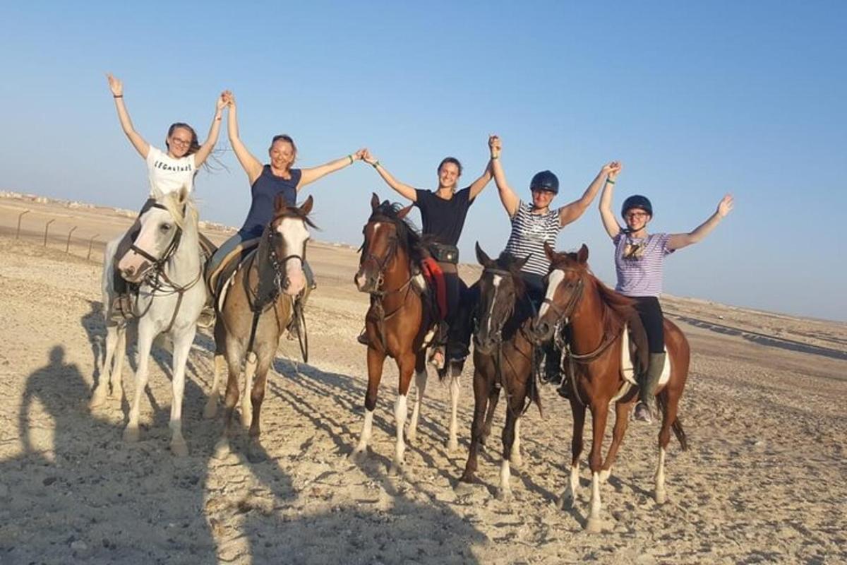 un groupe de personnes à cheval sur la plage