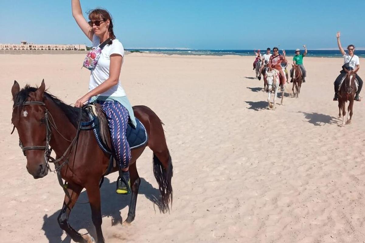 un groupe de personnes à cheval sur la plage