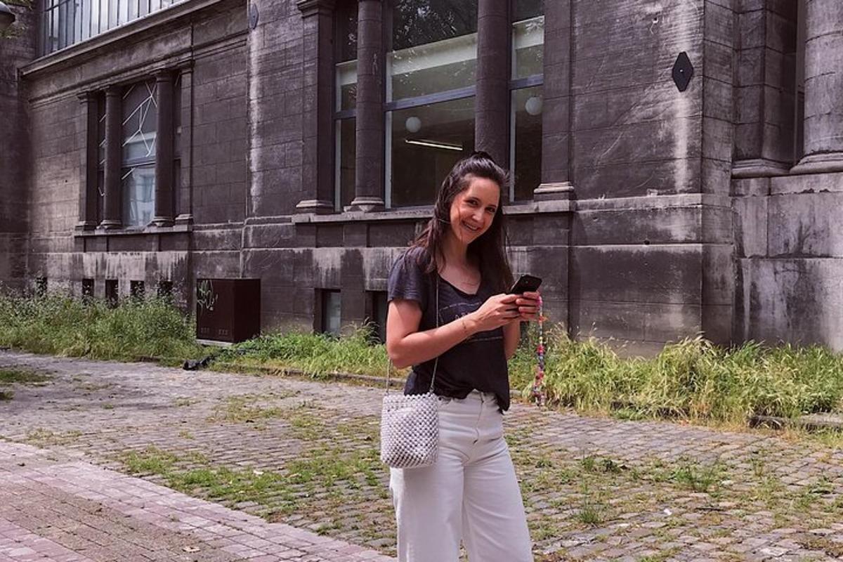 žena držící mobilní telefon před budovou