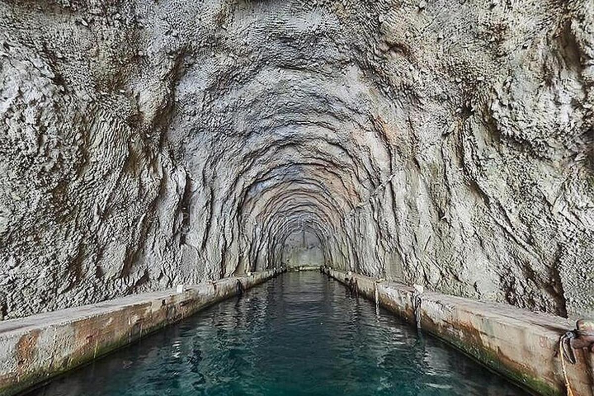 un tunnel in una parete rocciosa con acqua al suo interno