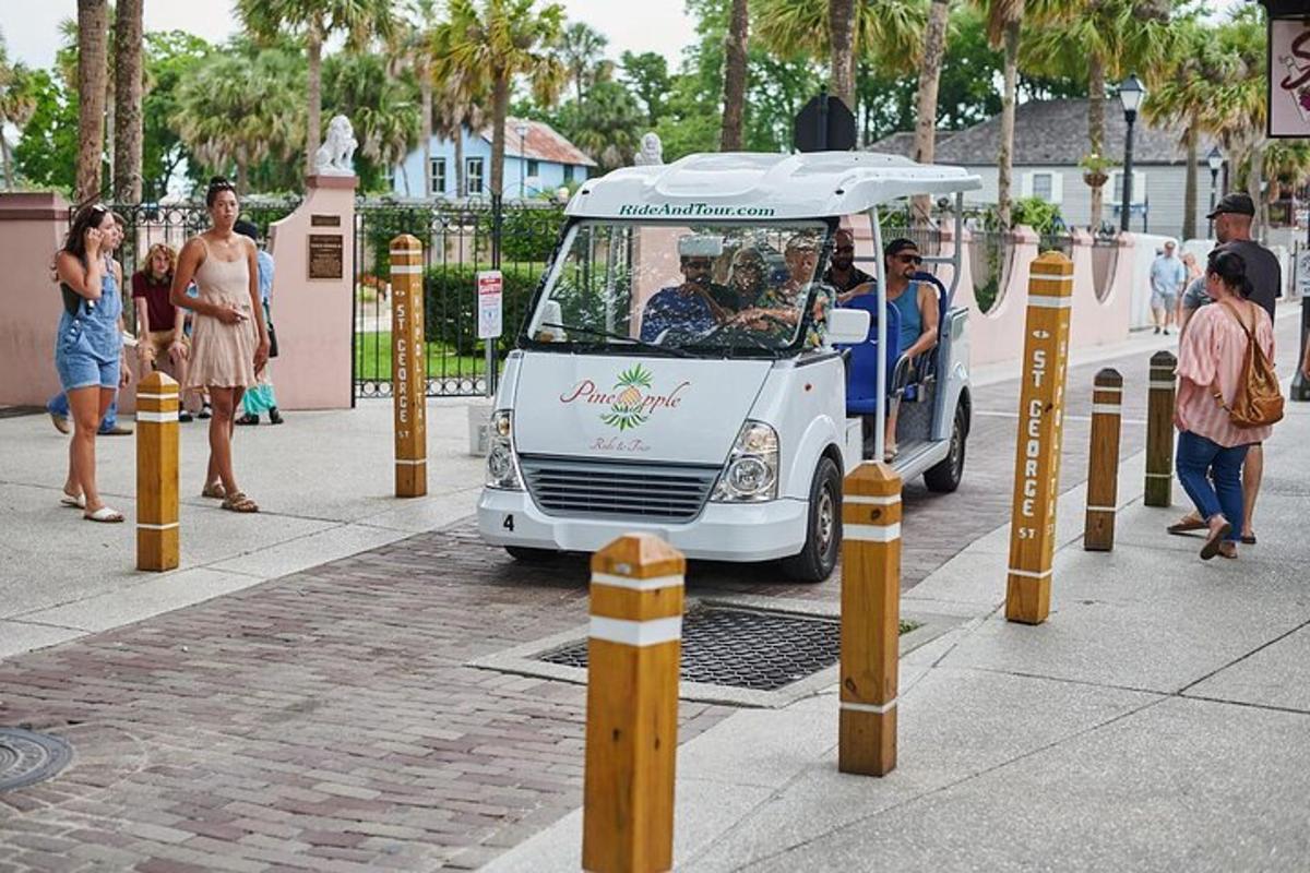 a white food cart with an umbrella on a street