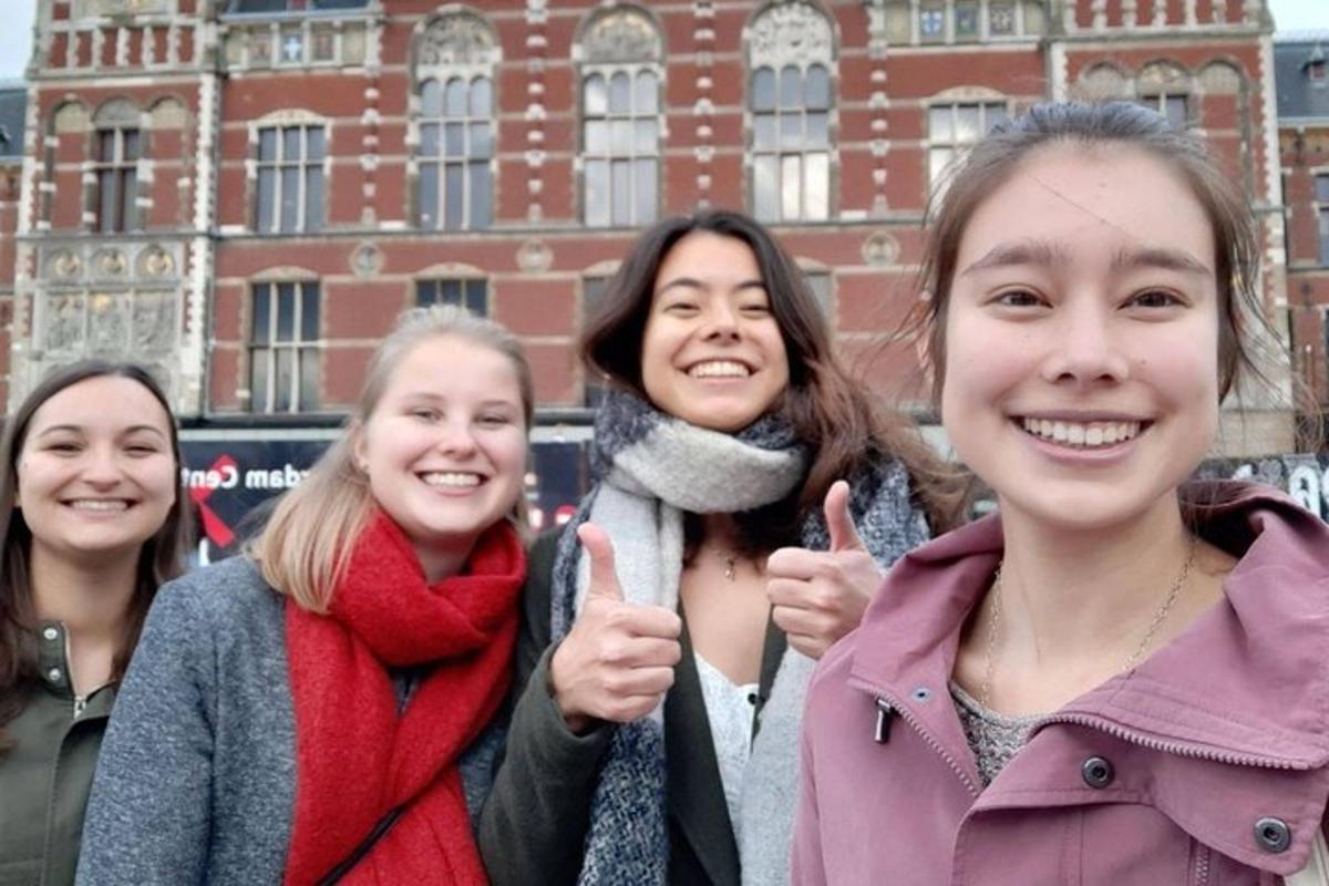 eine Gruppe von Frauen, die vor einem Gebäude den Daumen hochhalten