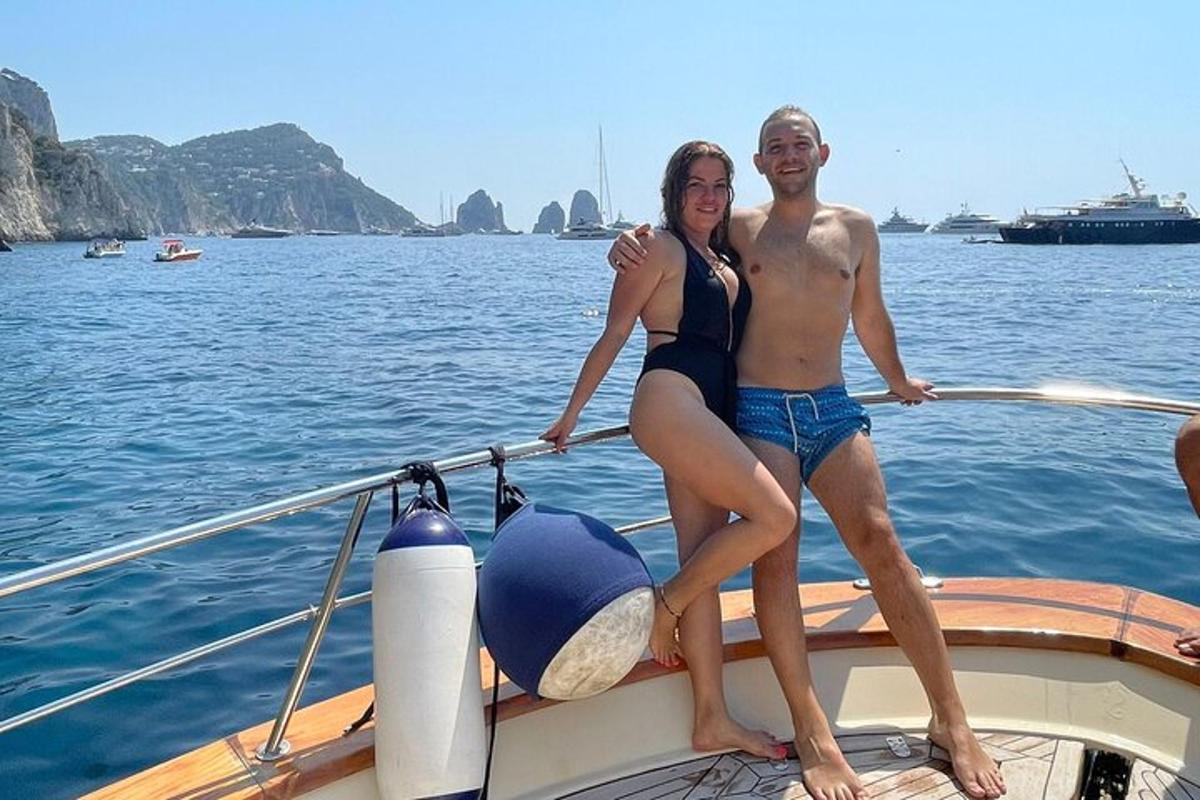 un uomo e una donna in piedi sulla prua di una barca