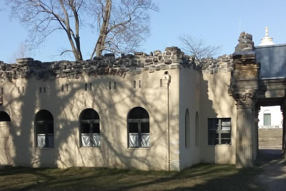 Stará kamenná budova s okny a stromem