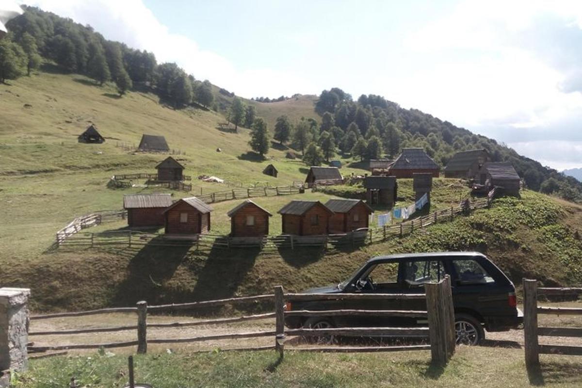 a truck parked on a hill with a farm