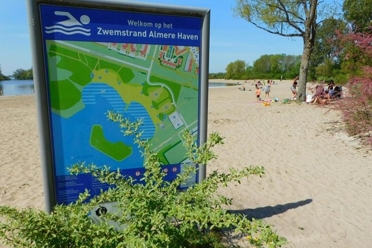 un cartello su una spiaggia con persone sullo sfondo