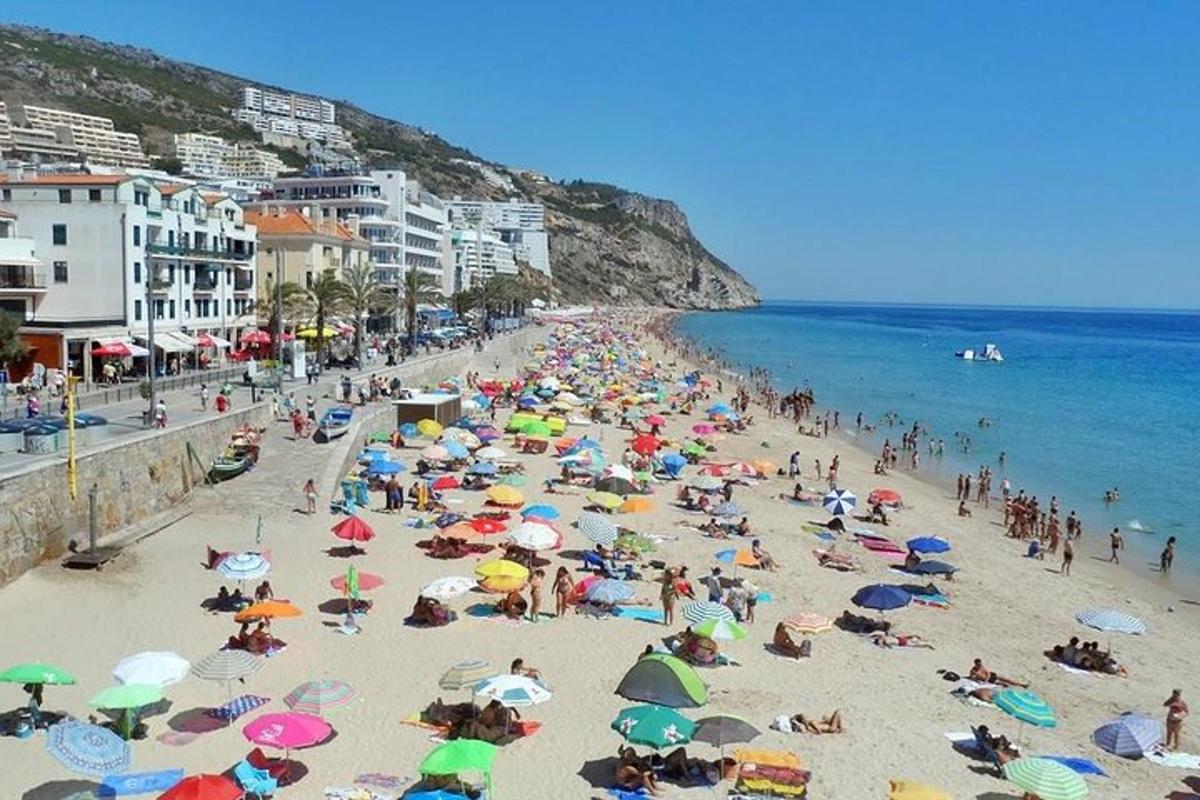 una multitud de personas en una playa con sombrillas