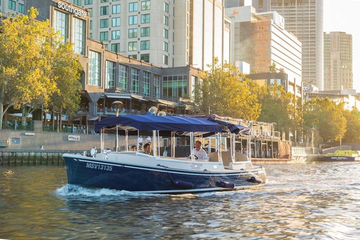 a boat with a blue canopy on a river with buildings