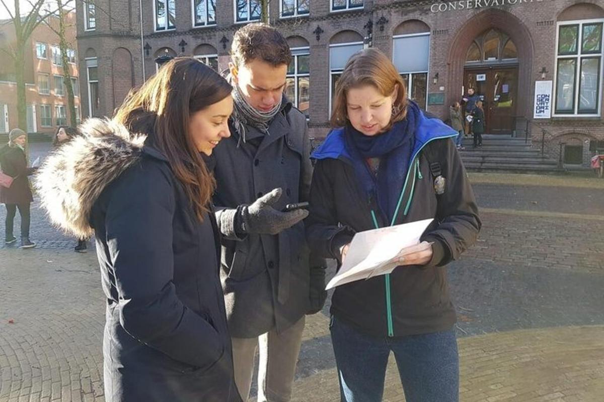 skupina tří lidí dívajících se na mobilní telefon
