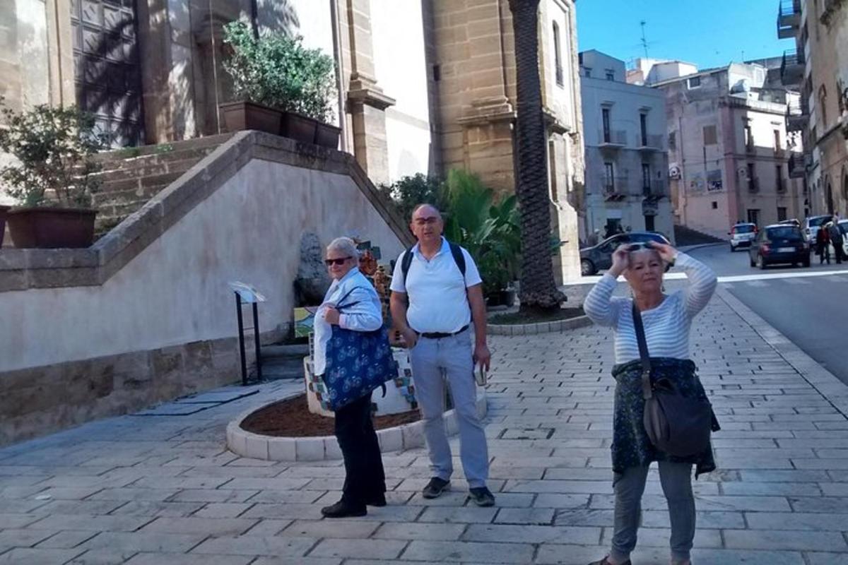 tre donne anziane in piedi su una strada cittadina