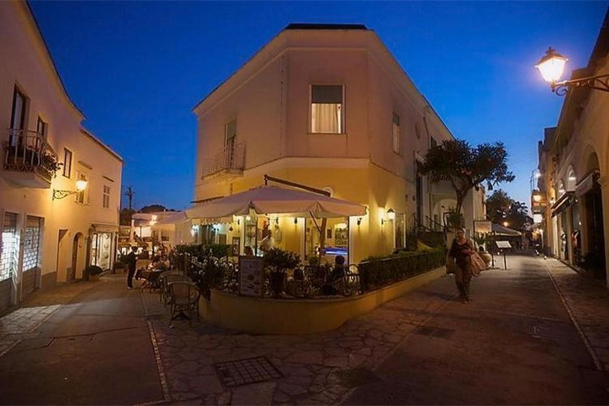μια γυναίκα περπατάει σε έναν δρόμο μπροστά από ένα κτίριο