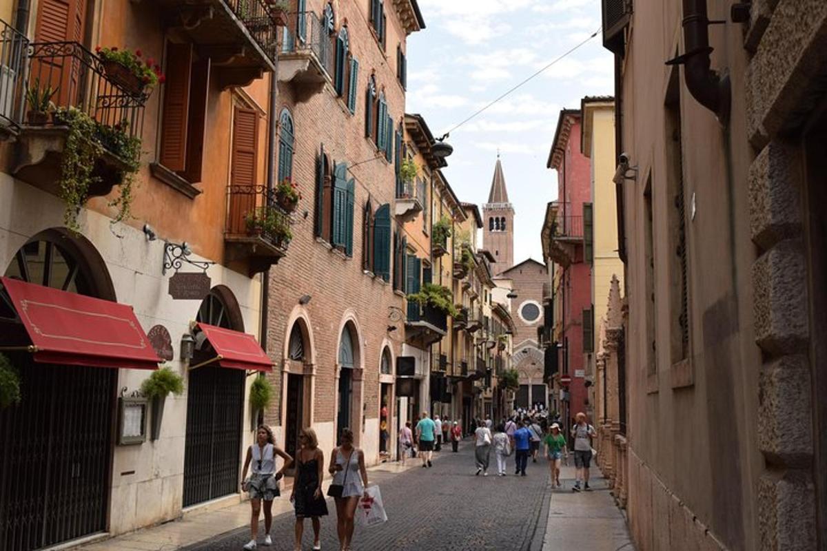 un gruppo di persone che camminano lungo una strada con edifici