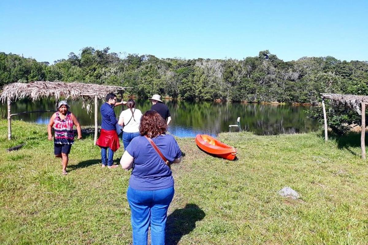 a group of people walking on the grass near a lake