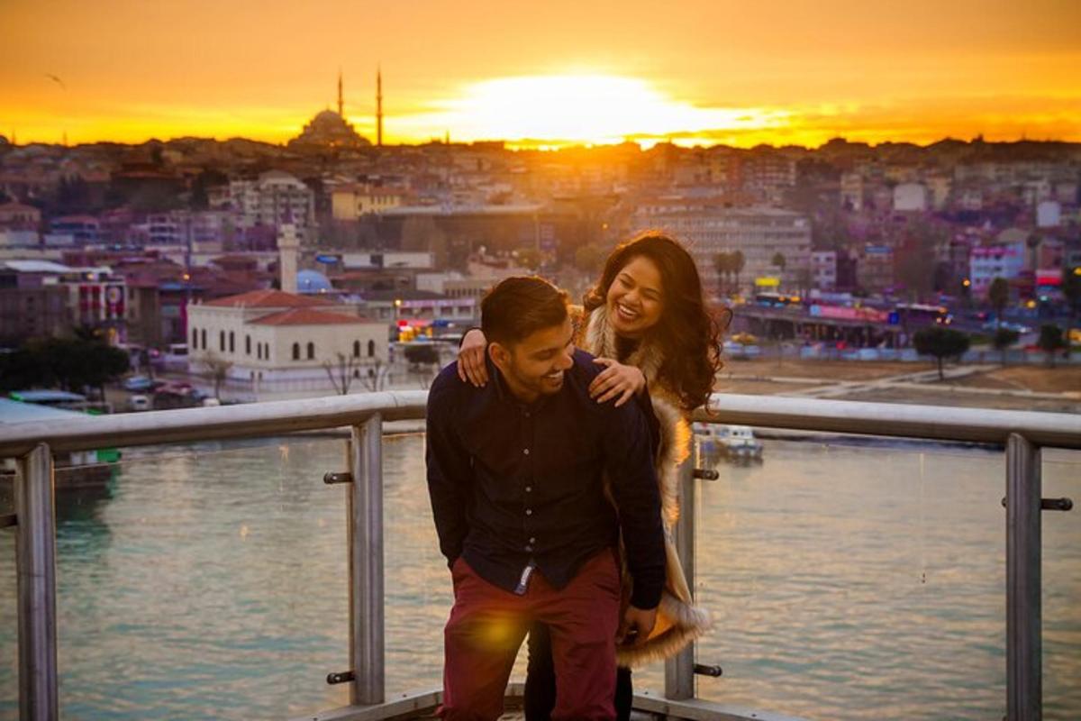 Un hombre y una mujer sentados en una barandilla con la puesta de sol.