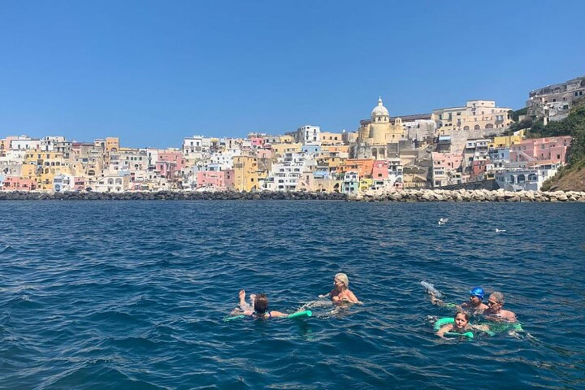 a group of people in the water in front of a city