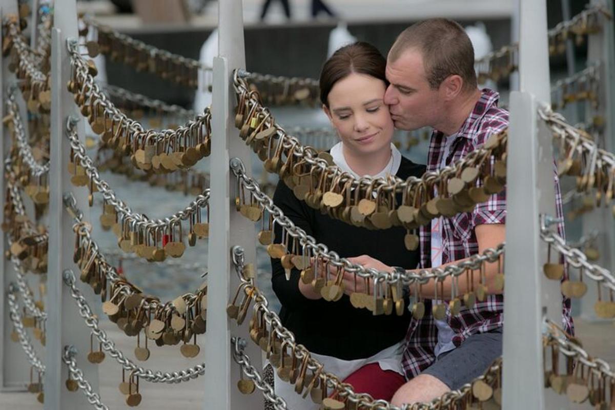 a man and woman looking at a row of necklaces