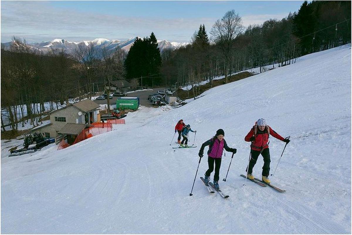 three people are skiing down a snow covered slope
