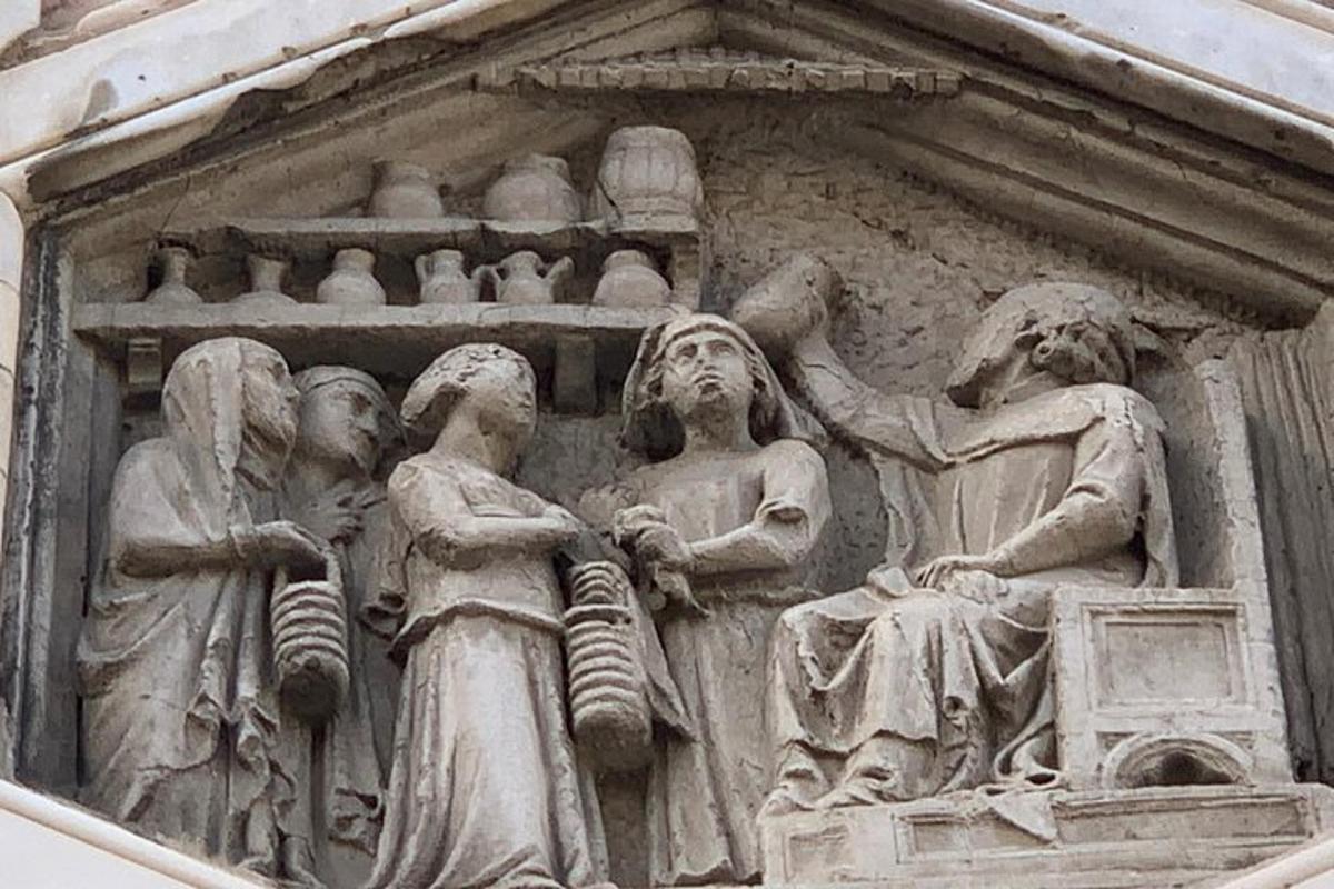 uma escultura de pedra de pessoas na lateral de um prédio