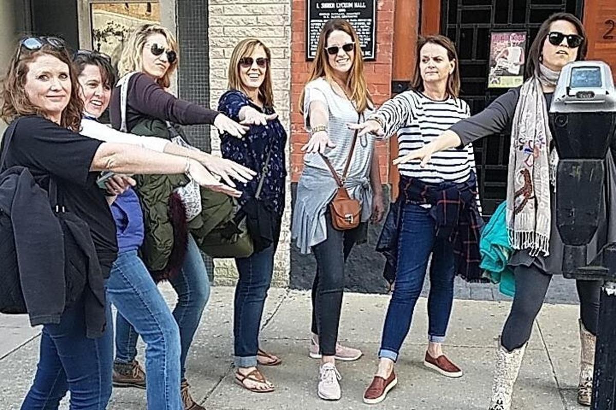 un gruppo di donne in piedi accanto a un parchimetro