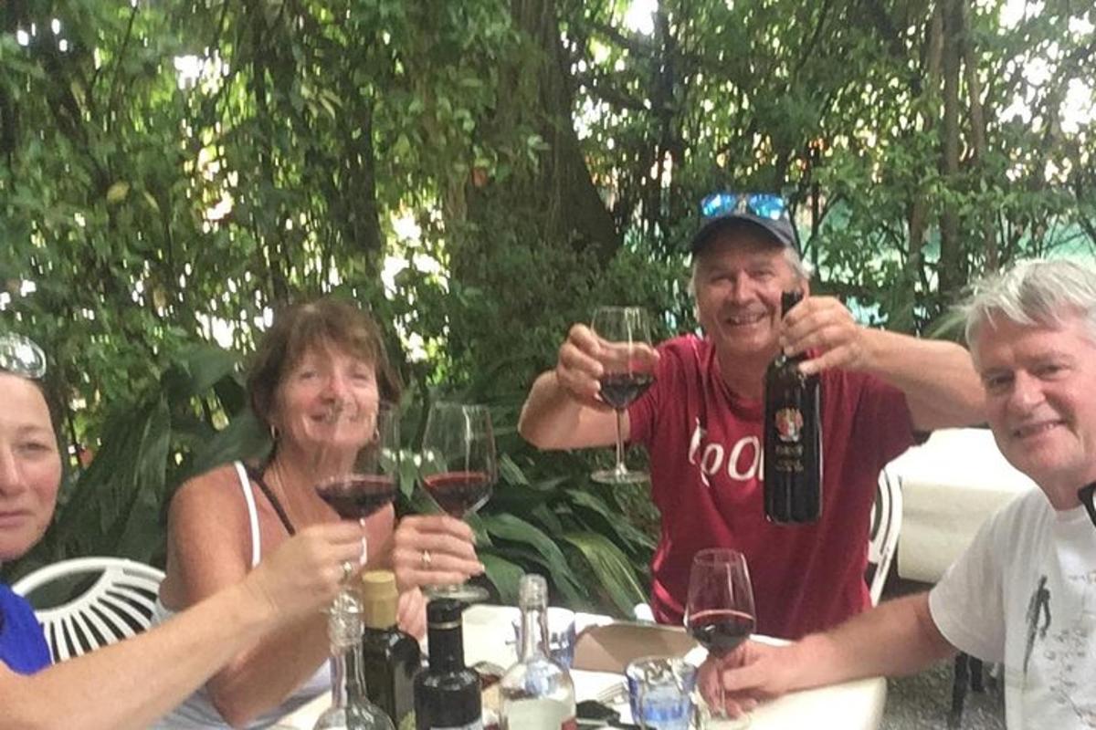 un gruppo di persone sedute a un tavolo che bevono vino