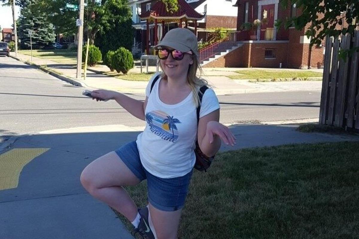 žena stojící na skateboardu na chodníku