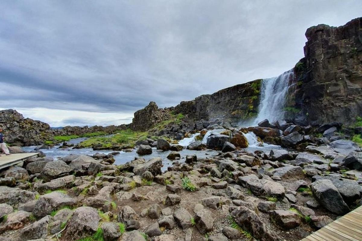 una cascada a la vora d'un riu amb roques