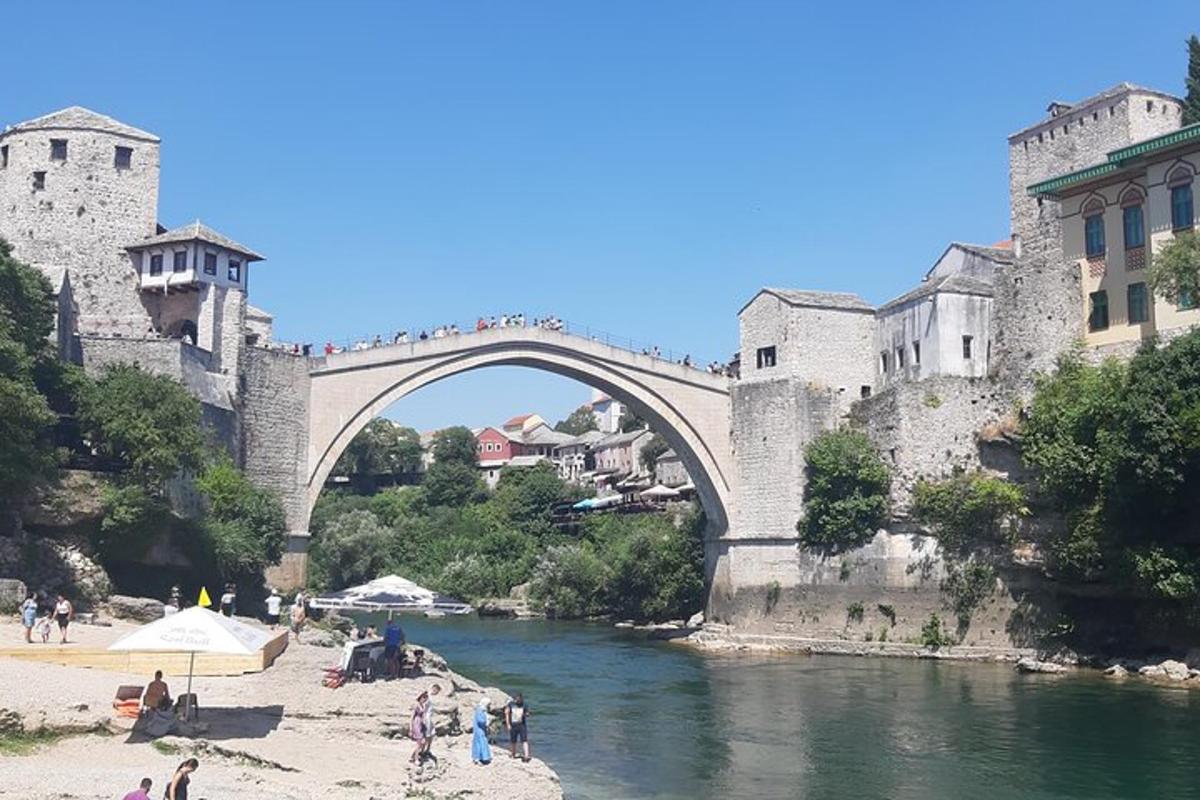 most čez reko z ljudmi, ki stojijo na plaži